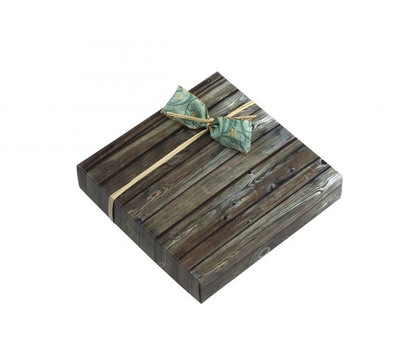 9er Schachtel "Essigschleckerle" von Schell Schokoladen ist eine Schachtel mit Holz Muster um die Schachtel herum ist eine grüne Schleife mit einem beigen band zu erkennen.