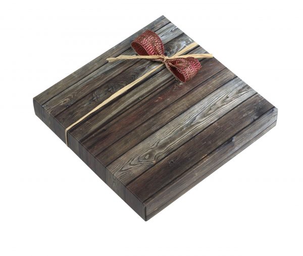 16er Schachtel "Essigschleckerle" von Schell Schokoladen ist eine Schachtel mit Holz Muster um die Schachtel herum ist eine rote Schleife mit einem beigen band zu erkennen.