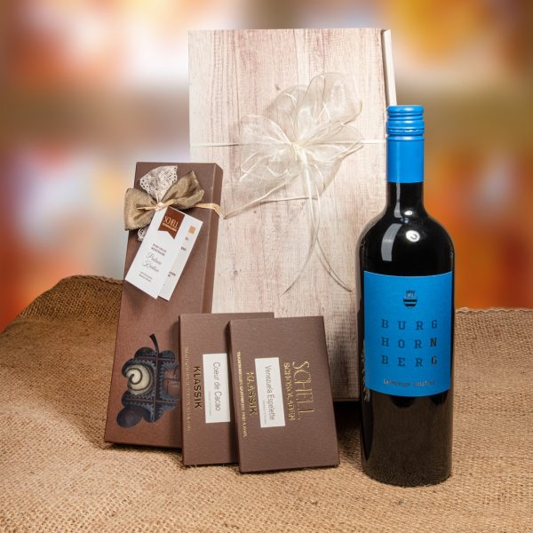 Geschenkpaket „Lemberger“ mit Pralinen mit je einer Tafel Coeur de Cacao in brauner Verpackung, sowie Venezuela Espelette. Zudem gibt es noch einen Lemberger Wein und eine 14er Schachtel mit der Kreation "Rund um den Wein" in einer braunen Verpackung mit einer Braunen und weißen schleife.